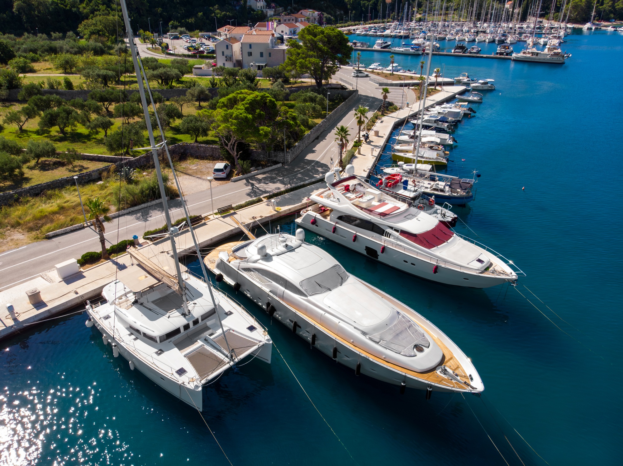 Scenic aerial view many yachts boats moored at Croatian bay harbor shore blue turquoise clear water