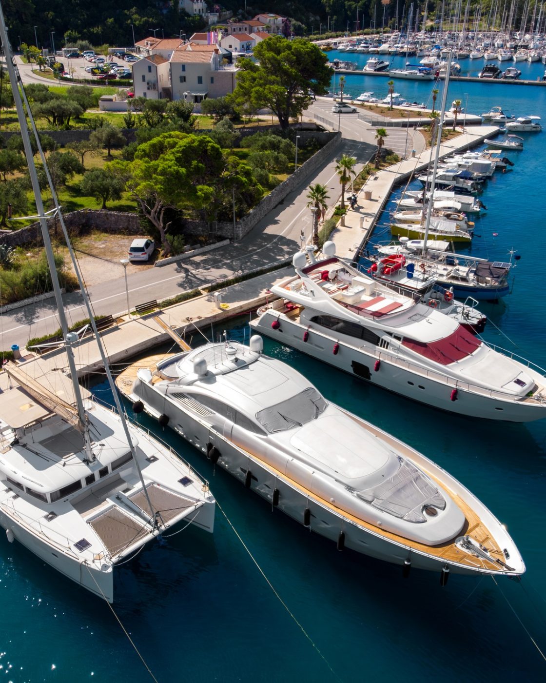 Scenic aerial view many yachts boats moored at Croatian bay harbor shore blue turquoise clear water Scenic aerial view many yachts boats moored at Croatian bay harbor shore blue turquoise clear water